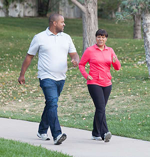 Two people walking in park.